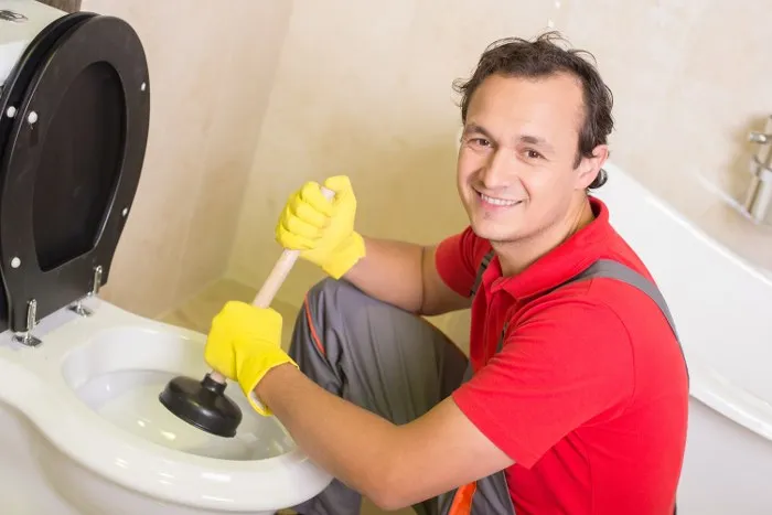 Engineer clearing a blocked toilet